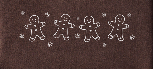 Four white gingerbread men with heart buttons on a brown background